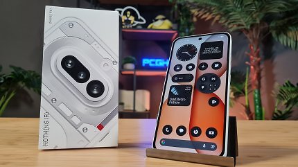 Ein Smartphone mit monochromen Apps steht neben der Packung auf einem Holztisch