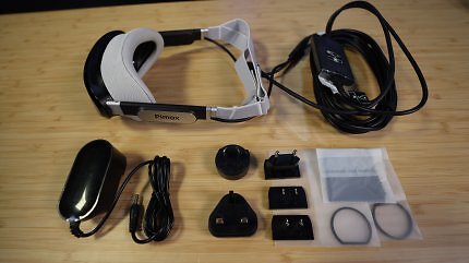 Die Pimax Dream Air samt Zubehör auf einem Holztisch