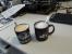 Herr Vötter ist vor allem durch seine 3dfx-Tasse bekannt, nicht zuletzt da diese einen quasi wöchentlichen Auftritt in dieser Artikelserie hat. Weniger bekannt ist allerdings, dass Raff die Tasse für reichlichen Kaffee-Genuss nutzt. Aufgrund des Volumens ist die 3dfx-Tasse dafür aber nicht besonders gut geeignet. Raff löst das Problem auf elegante Art und Weise, indem er sich den Kaffee zukünftig in zwei Trinkgefäßen heranschafft.