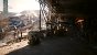 Pathtraced (DLSS 3.5 mit Performance-Upsampling). Achten Sie auf den Schriftzug der Container (links) sowie die Beleuchtung und Gesichter der NPCs (rechts).