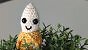 Eine gehäkelte Banane in einer Kunstpflanze