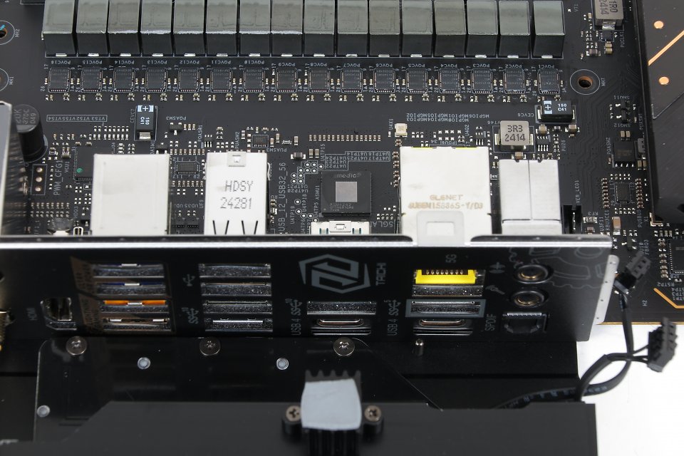 ASMedias ist (mittig zwischen Spannungswandlern und I/O) ist für einen USB-Controller erstaunlich groß und wird u.a. bei Asrock aktiv gekühlt (Unterseite des X870E-Taichi-Kühlers im Vordergrund).