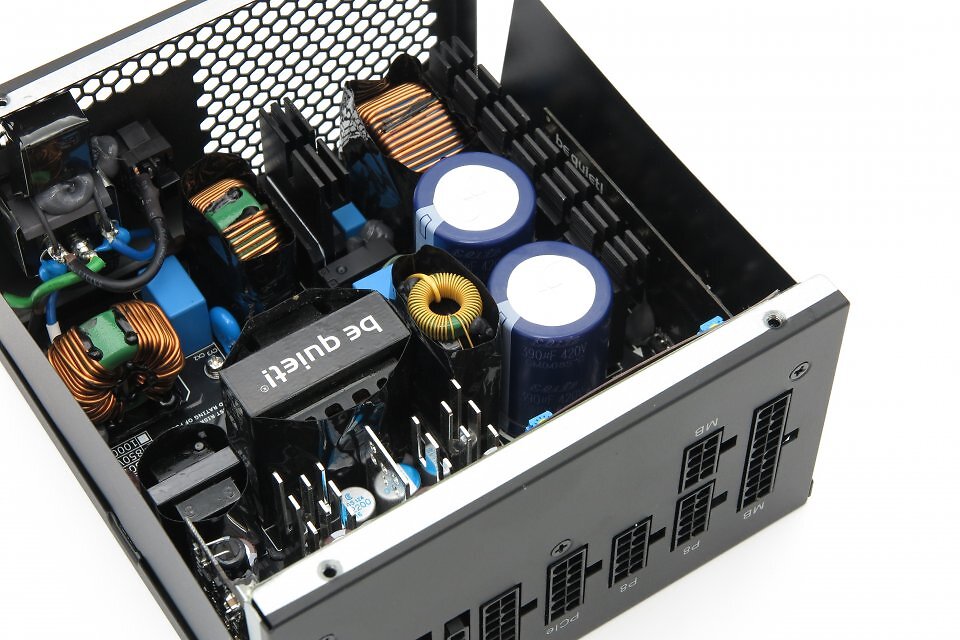Aufgeräumt und unauffällig. Abseits der zwei blauen Primärkondensatoren von Elite (taiwanesischer Hersteller). Die Größe ist kein Problem, 2× 420 V 390 μF(M) genügen absolut, wie man an der soliden Hold-up-Time auch messen kann. Schade ist nur der Sparkurs: Statt der in der Leistungs- und Preisklasse üblichen 105 °C sind die größeren Kondensatoren mit 85 °C spezifiziert. Immerhin: Der Nutzer würde den Unterschied nicht bemerken. Und die Garantie ist mit 10 Jahren im grünen Bereich.