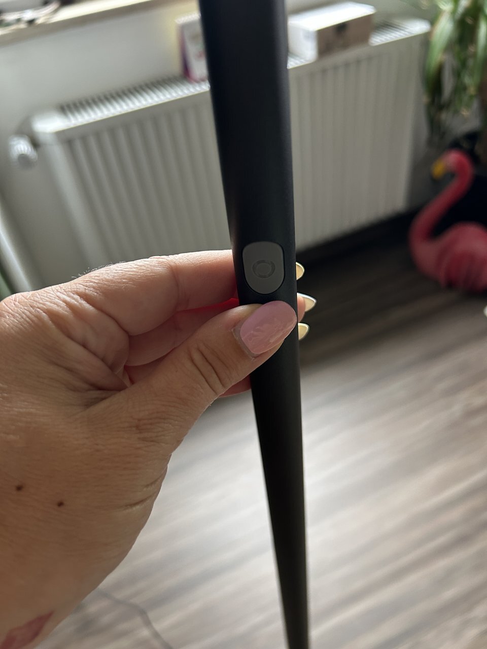 An der Stange befindet sich ein Knopf, mit dem man die Stehlampe manuell aus- und einschalten kann.