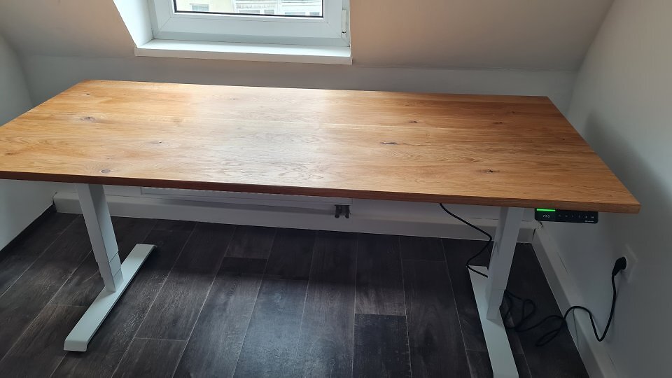 Ein höhenverstellbarer Schreibtisch unter einer Dachschräge.