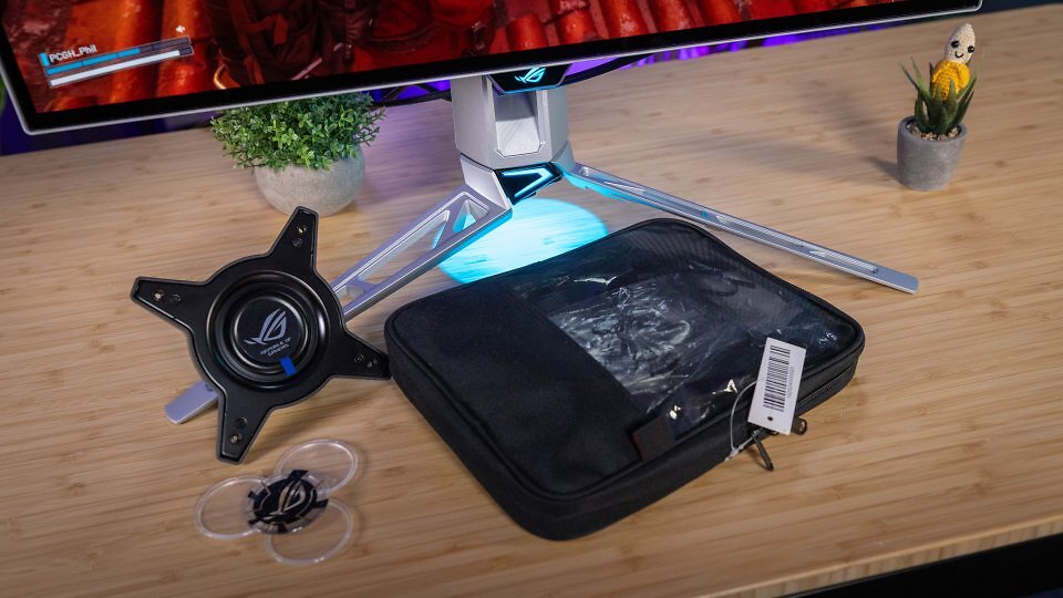 Asus legt dem PG27AQWP-W einen VESA-Adapter (zur Wandmontage oder für eine entsprechende Monitorhalterung), einige Schablonen für das auf die Tischplatte projizierte Logo sowie eine nützliche Kabeltasche bei, die neben Stromkabel, einer HDMI-2.1-Strippe und einem Mikrofaserputztuch obendrein ein mit 1,80 Metern üppig dimensioniertes DP80-Kabel für volle, kompressionsfreie Befeuerung enthält.
