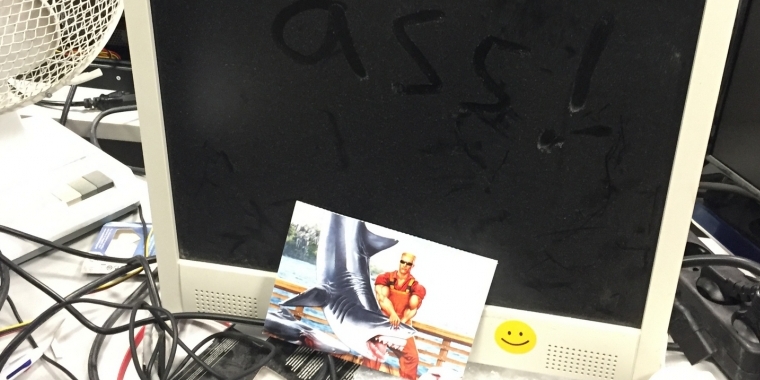 Wem dieser Monitor gehört, auf dem sich so viel Staub angesammelt hat, dass man dort schon ein böses und bevorzugt vom FluchPhil geäußertes Wort niederschreiben kann, verraten wir nicht. Und um ihren Blick auch schnell wieder von dem Hauptwort der Reutherschen Unmutsbekundungen abzulenken, haben wir noch eine schöne Postkarte dazugestellt. Den Herrn auf der Karte sollten die meisten kennen, zumal der Duke seine Fans sehr, sehr lange auf seinen neuesten Spielauftritt hat warten lassen. Viel witziger ist, dass es sich hier um eine Teilnahmekarte für unser Gewinnspiel zum 15-jährigen Bestehen der PCGH handelt. Da wollte wohl jemand das Glück mit einem besonders schönen Eye Catcher positiv beeinflussen.